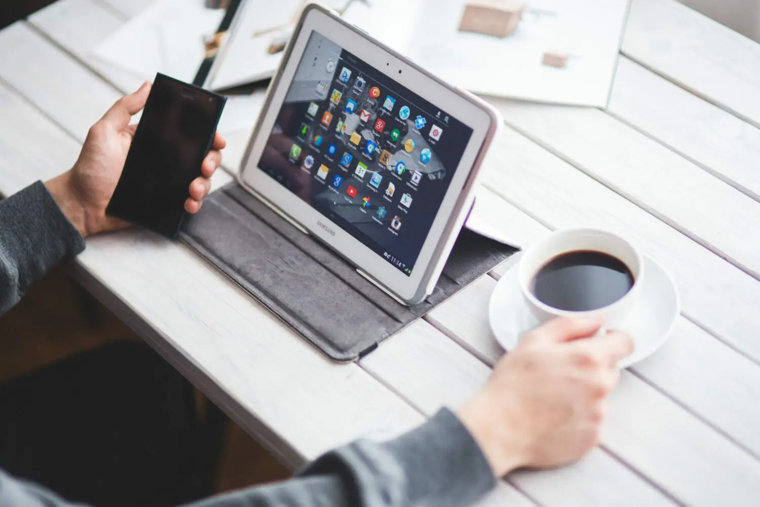 Social media manager working diligently on tablet and smartphone.