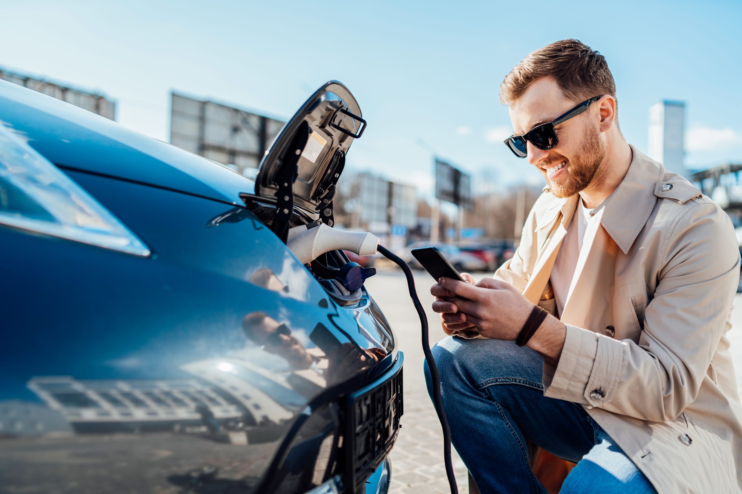 The car is waiting. Мужчина рядом с автомобилем со смартфоном. Авто позитивное. Парень с аккумулятором. Парень с аккумулятором в руках.