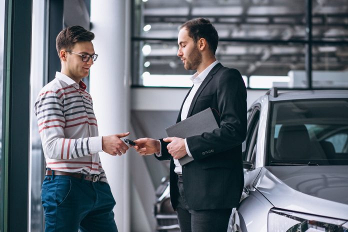 Car salesperson using dealership marketing technology to proactively promote customer loyalty