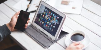 What to look for when hiring a social media manager for your dealership Social media manager working diligently on tablet and smartphone.