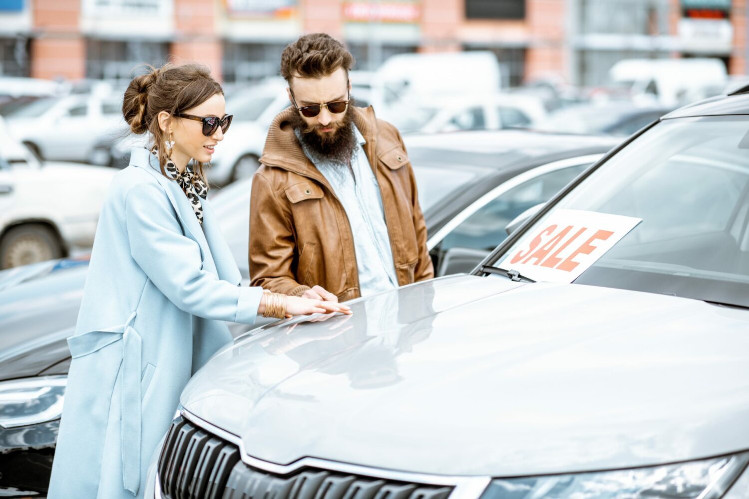 Young couple looking at used car inventory